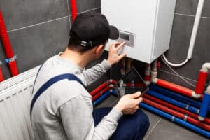 The technician checking the heating system in the boiler room wi